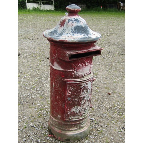 1017 - A painted and weathered cylindrical cast metal post box with raised relief detail beneath a fixed do... 