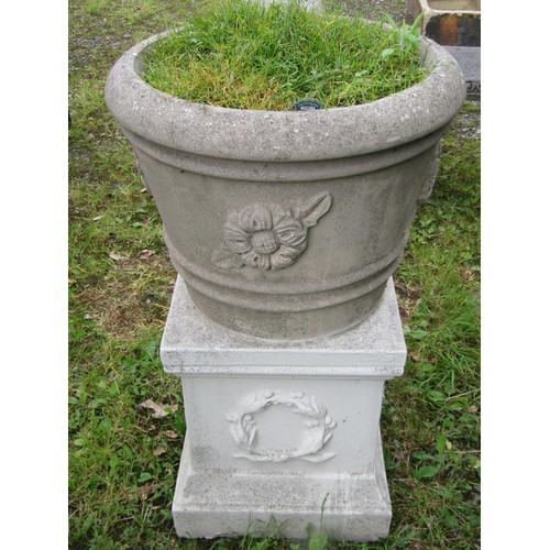 1029 - A weathered cast composition stone garden planter of circular tapered and ribbed form with raised fl... 