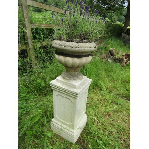 1030 - A painted cast composition stone garden urn, the squat circular lobed bowl set on a fixed socle and ... 