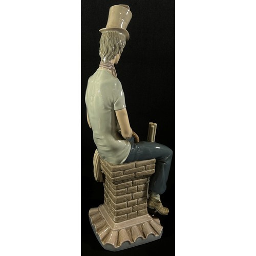 57 - A large Lladro figure of a chimney sweep seated upon a chimney stack holding a cat 'Sad Chimney Swee... 