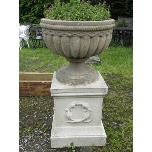 1033 - A weathered cast composition stone garden urn, the squat circular lobed bowl with rope twist and lat... 