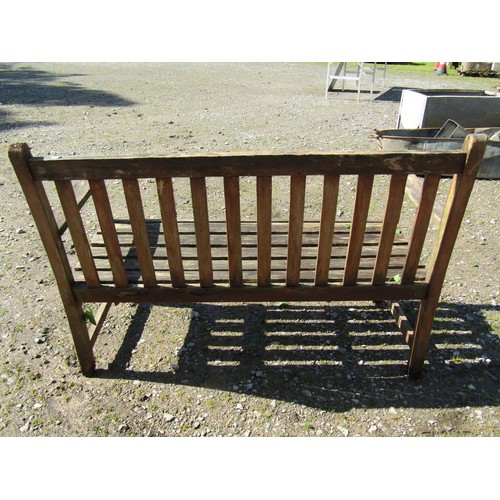 1053 - A weathered teak two seat garden bench with slatted seat and back (af) 130 cm wide