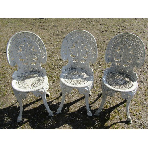 1063 - A set of weathered cream painted cast aluminium garden terrace chairs with decorative pierced geomet... 