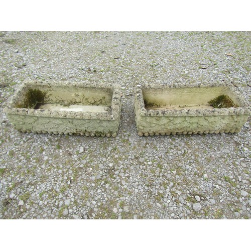 1074 - A pair of weathered rectangular composition stone flower troughs with repeating acorn and oak leaf r... 