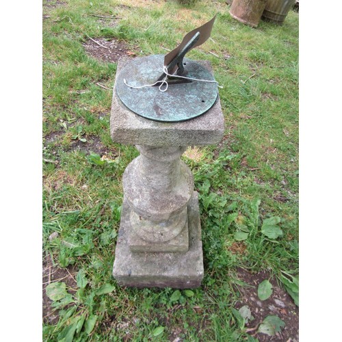 1076 - A garden sundial of circular form with pierced gnomon set on a weathered cast composition stone balu... 