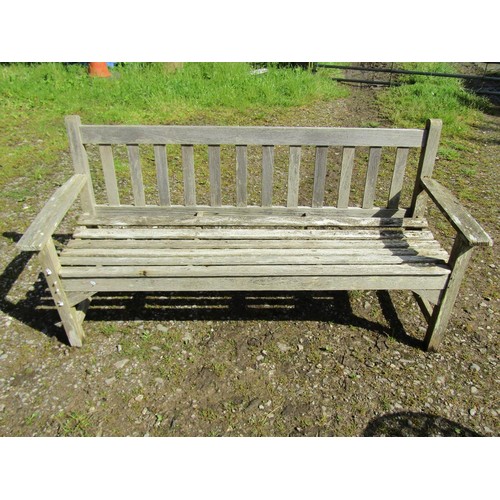 1060 - An R A Lister & Co Ltd weathered teak three seat garden bench with slatted seat and back 158 cm long