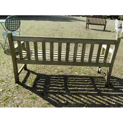 1060 - An R A Lister & Co Ltd weathered teak three seat garden bench with slatted seat and back 158 cm long