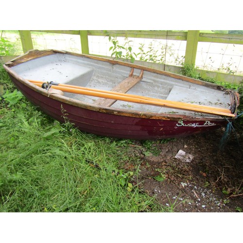 1110 - A small painted rowing boat with fibreglass hull and wood trim named Sweet Pea, complete with a pair... 