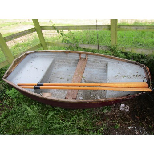 1110 - A small painted rowing boat with fibreglass hull and wood trim named Sweet Pea, complete with a pair... 