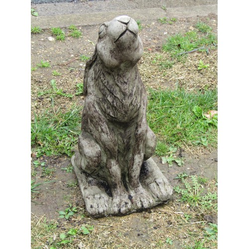 1122 - A weathered cast composition stone garden ornament in the form of a seated moongazing hare, 47 cm hi... 