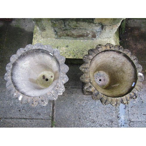 1132 - A pair of weathered cast composition stone garden urns with trumpet shaped foliate bowls set on a fi... 