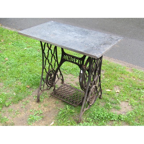 1133 - A Singer cast iron treadle sewing machine base later used as a garden table with associated rectangu... 