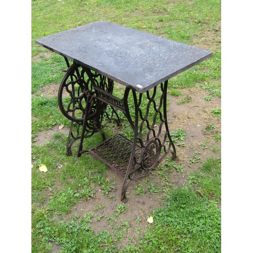 1133 - A Singer cast iron treadle sewing machine base later used as a garden table with associated rectangu... 