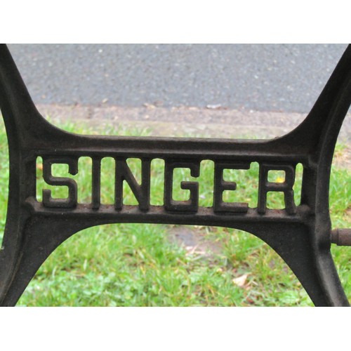 1133 - A Singer cast iron treadle sewing machine base later used as a garden table with associated rectangu... 