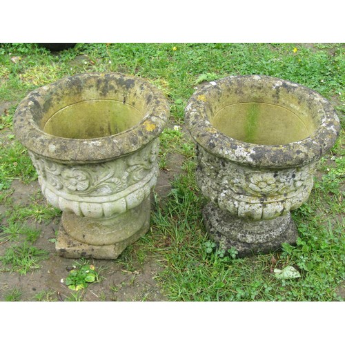 1144 - A pair of weathered cast composition stone garden urns, the circular lobed bowls with repeating scro... 