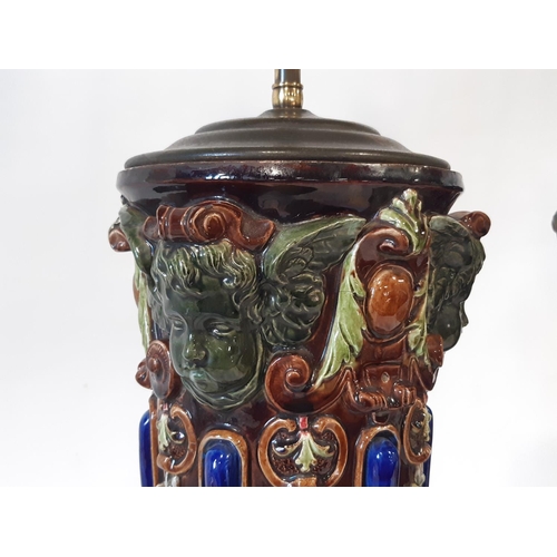 30 - A tall and impressive pair of majolica type table lamps, each with articulated twin lights over tape... 