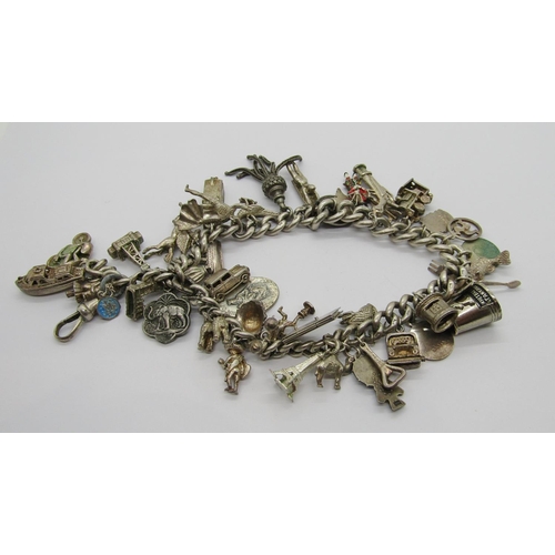 414 - Silver charm bracelet formed from an antique silver Albert chain, novelty charms to include a Drivin... 