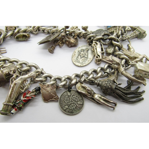 414 - Silver charm bracelet formed from an antique silver Albert chain, novelty charms to include a Drivin... 