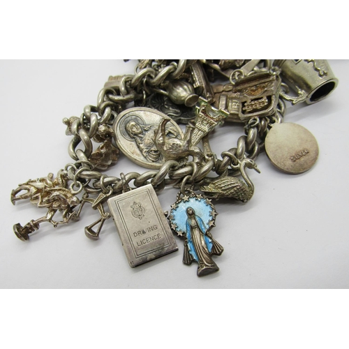 414 - Silver charm bracelet formed from an antique silver Albert chain, novelty charms to include a Drivin... 