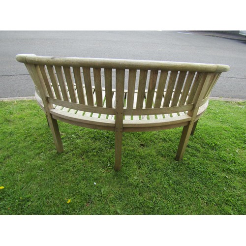 1153 - A weathered teak banana shaped garden bench 158 cm