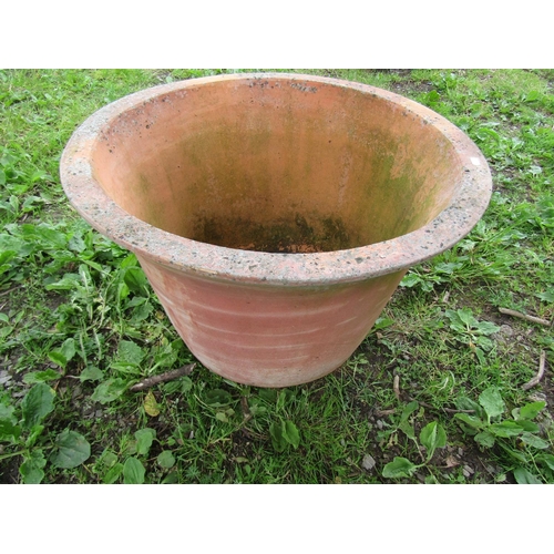 1082 - A large weathered terracotta planter of circular tapered form with flared rim 48 cm high x 72 cm dia... 