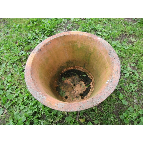 1082 - A large weathered terracotta planter of circular tapered form with flared rim 48 cm high x 72 cm dia... 