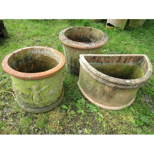 1083 - Three weathered terracotta garden planters of varying size and design, two cylindrical and one demi-... 