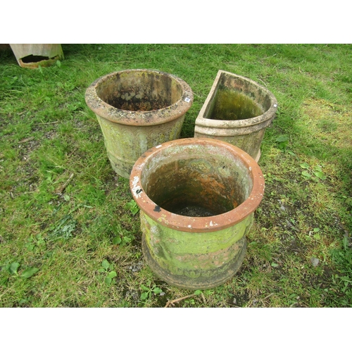 1083 - Three weathered terracotta garden planters of varying size and design, two cylindrical and one demi-... 