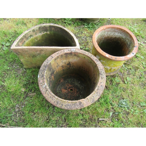 1083 - Three weathered terracotta garden planters of varying size and design, two cylindrical and one demi-... 