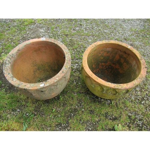 1085 - A matched pair of weathered terracotta squat oviform planters with repeating arched moulded gothic r... 