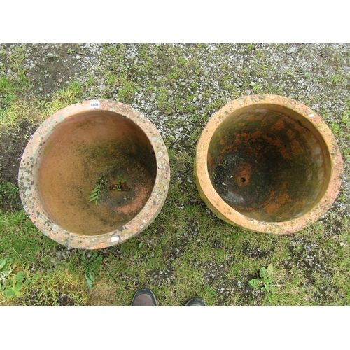 1085 - A matched pair of weathered terracotta squat oviform planters with repeating arched moulded gothic r... 