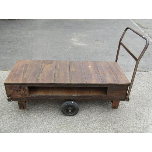 1687 - A vintage four wheeled platform trolley with wooden bed and tubular steel handle, the bed 130 x 56 c... 