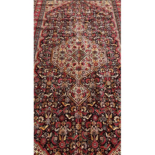 1781 - A Machine made Persian style carpet with an extended central medallion on a floral ground 298 x 150 ... 