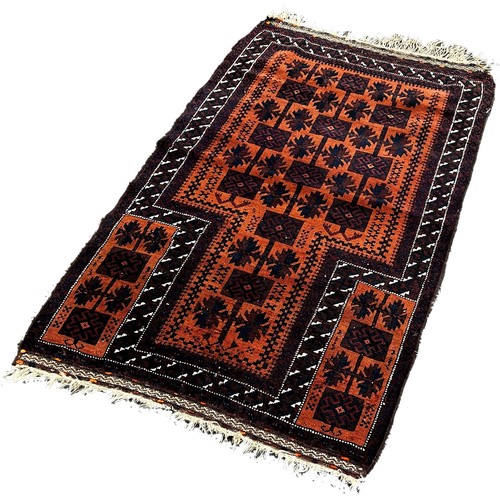 1771 - A Baluch Rug with black interlocking squares on an orange ground, 140 x 80cm approximately