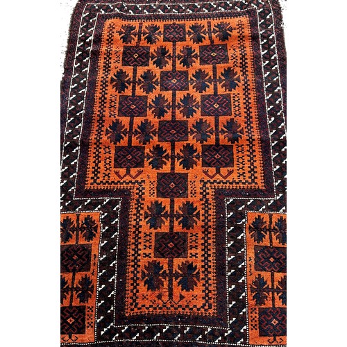 1771 - A Baluch Rug with black interlocking squares on an orange ground, 140 x 80cm approximately