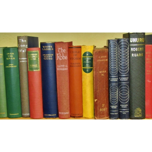 694 - A large library of literature hard backs including examples by Galsworthy, Moorehead, Shute, Rider H... 