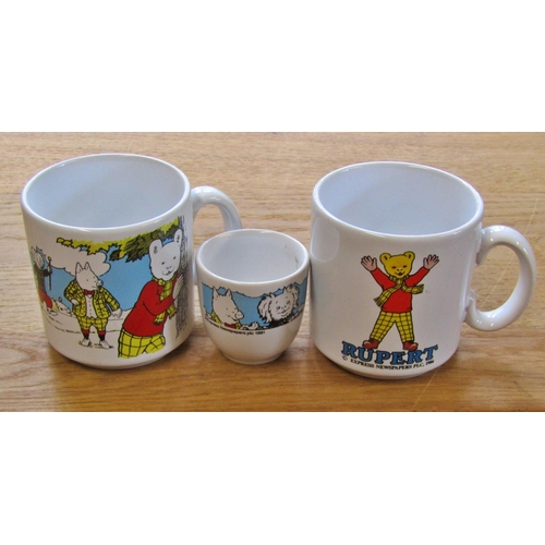 702 - A miscellaneous collection of Rupert the Bear memorabilia to include six die-cast transport toys (bo... 