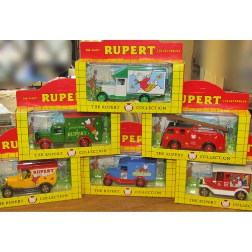 702 - A miscellaneous collection of Rupert the Bear memorabilia to include six die-cast transport toys (bo... 