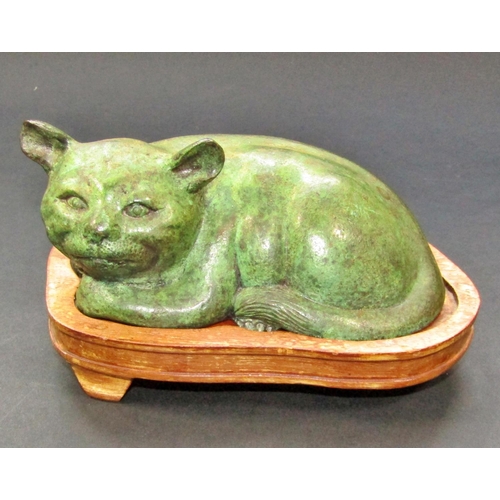 446 - Chinese bronze figure of a recumbent cat on a hardwood base, 15cm max