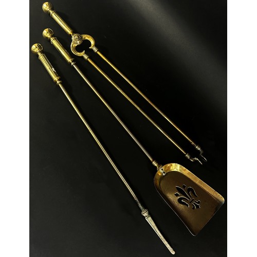 609 - A set of three 19th century brass fire tools, poker, tongs, shovel and a beaten copper  bellows