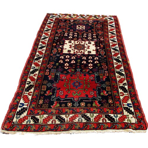 1777 - An Antique Persian Karaja rug with a central cream medallion with floral decoration on a blue ground... 