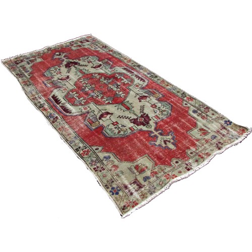 1779 - An old and faded Oushak rug with an extended central panel of stylised flowers, 220cm x 115cm approx... 