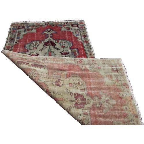 1779 - An old and faded Oushak rug with an extended central panel of stylised flowers, 220cm x 115cm approx... 