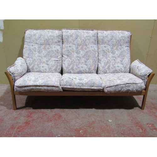 1723 - A pale Ercol three seat sofa with a pale coloured upholstery and blonde wood frame