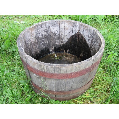 1090 - A weathered coopered oak and steel banded half barrel planter, 39 cm high x 64 cm diameter, together... 