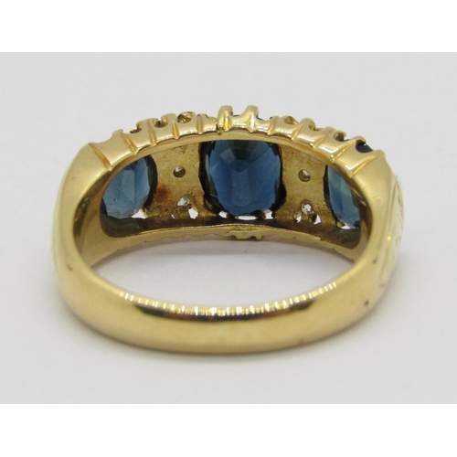 335 - Antique style 18ct claw set three stone sapphire and diamond ring with engraved detail to shoulders,... 