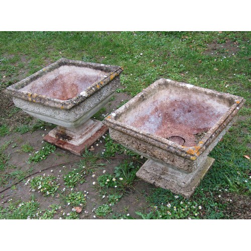 1194 - A pair of weathered cast composition stone garden urns, the square tapered bowls with repeating rose... 