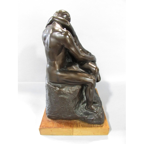 523 - “The Kiss” after Rodin in a bronzed resin finish, set on a wooden plinth, 30cm high over all.