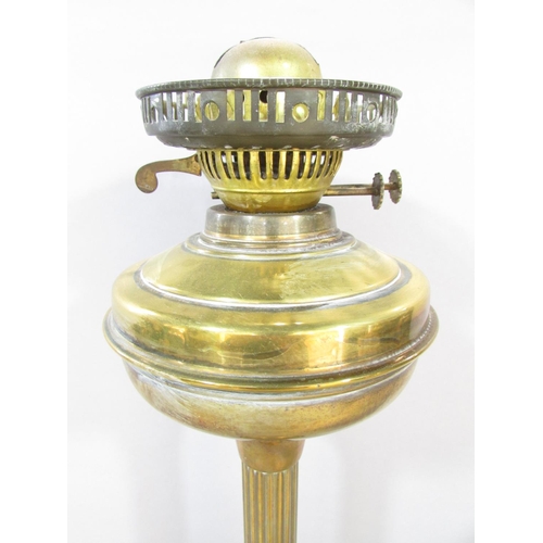 556 - A Victorian brass column oil lamp with a cracked cranberry red font and an opaque shade, together wi... 