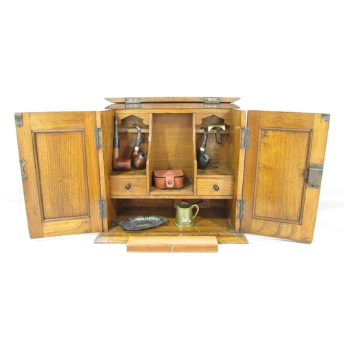 565 - An Arts and Crafts smokers cabinet with copper panelled doors opening to reveal two drawers, three p... 